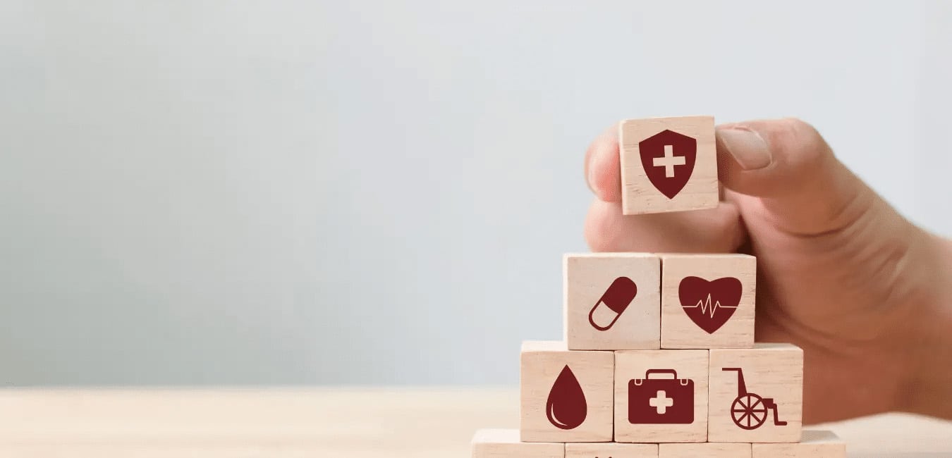 Man's hand stacking blocks with health symbols on them
