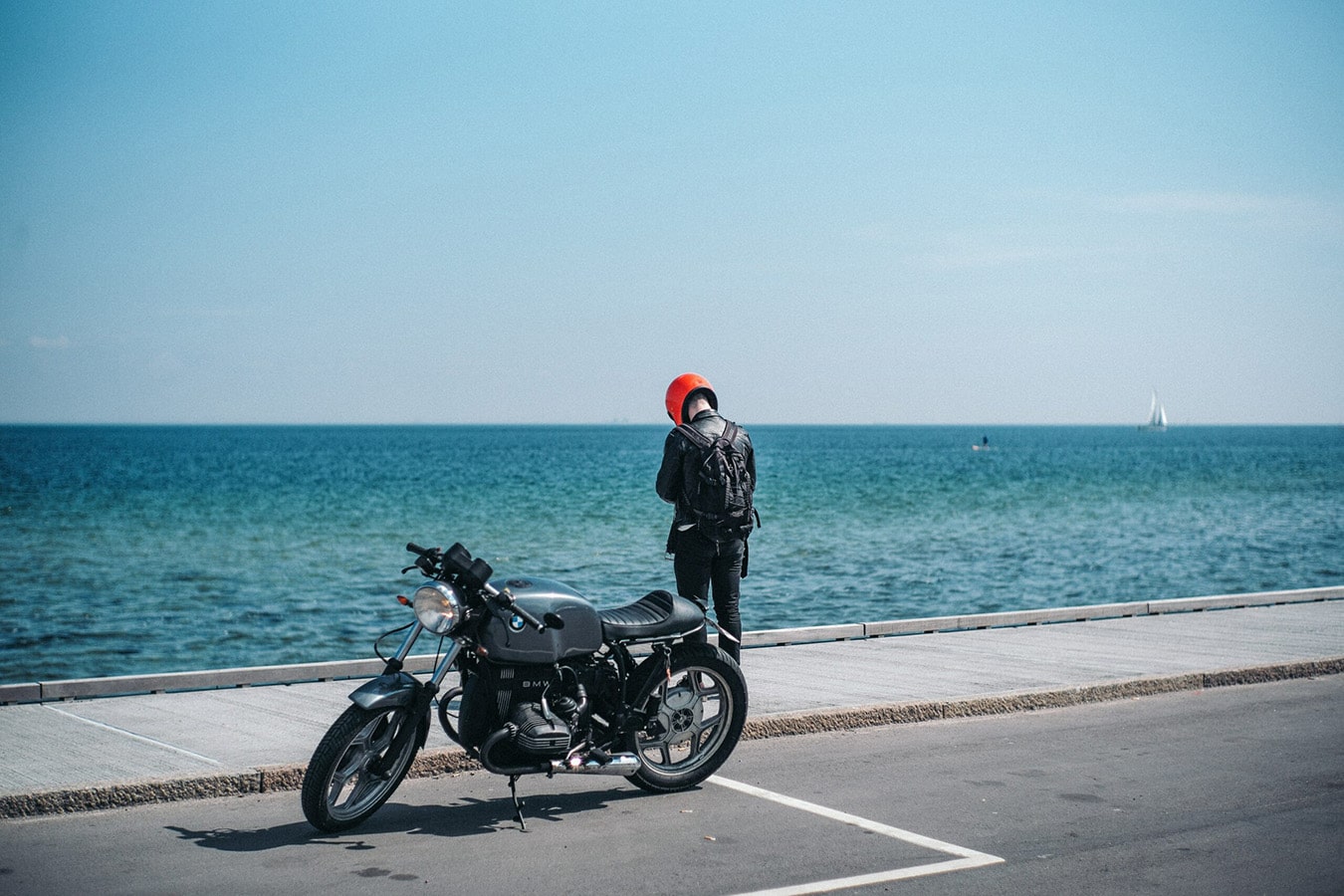 Man with motorcycle by seas edge